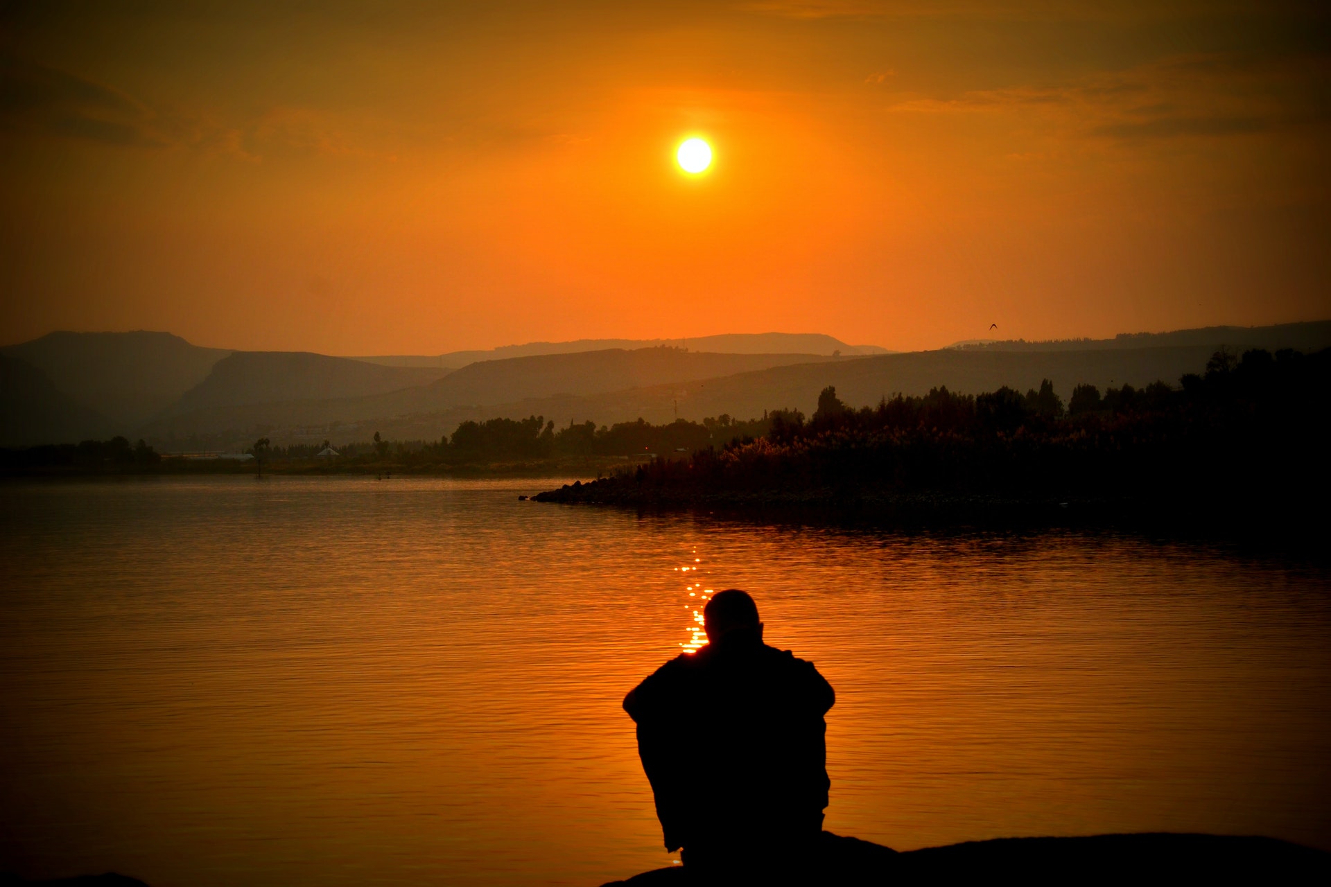 home diante do pôr do sol, contemplando a vista